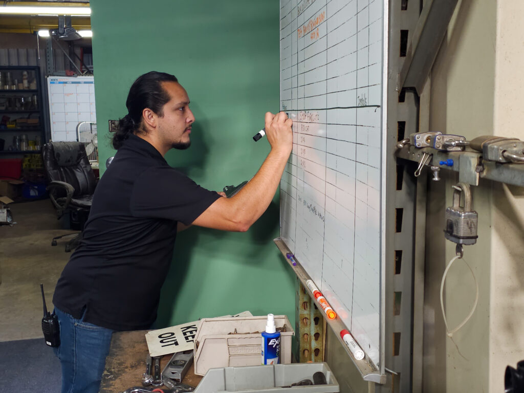 A warehouse worker on the whiteboard. during a planning session. Productivity in warehousing.