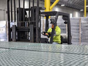 A forklift driver operating in a warehouse safely