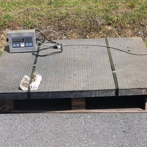 A used Floor Scale sitting outside on a wooden pallet which is sitting on asphalt with a patch of grass behind it.