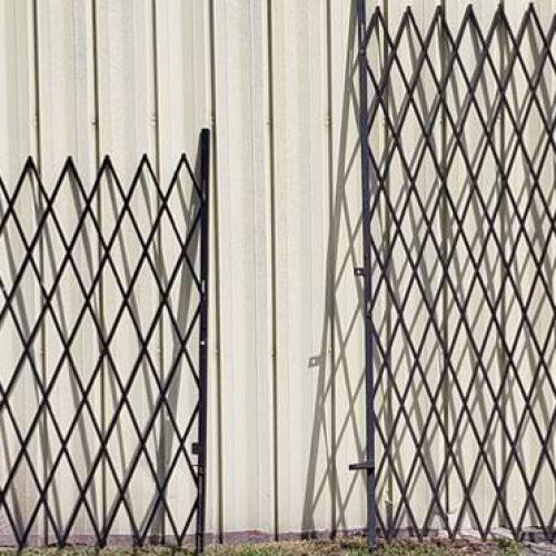 Used Metal Security Gates leaning up against the exterior wall of a warehouse